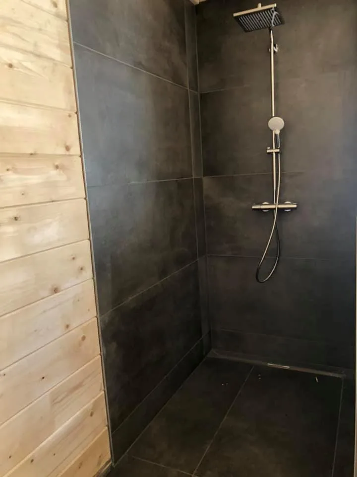 Dusche mit dunklen großformatigen Fliesen